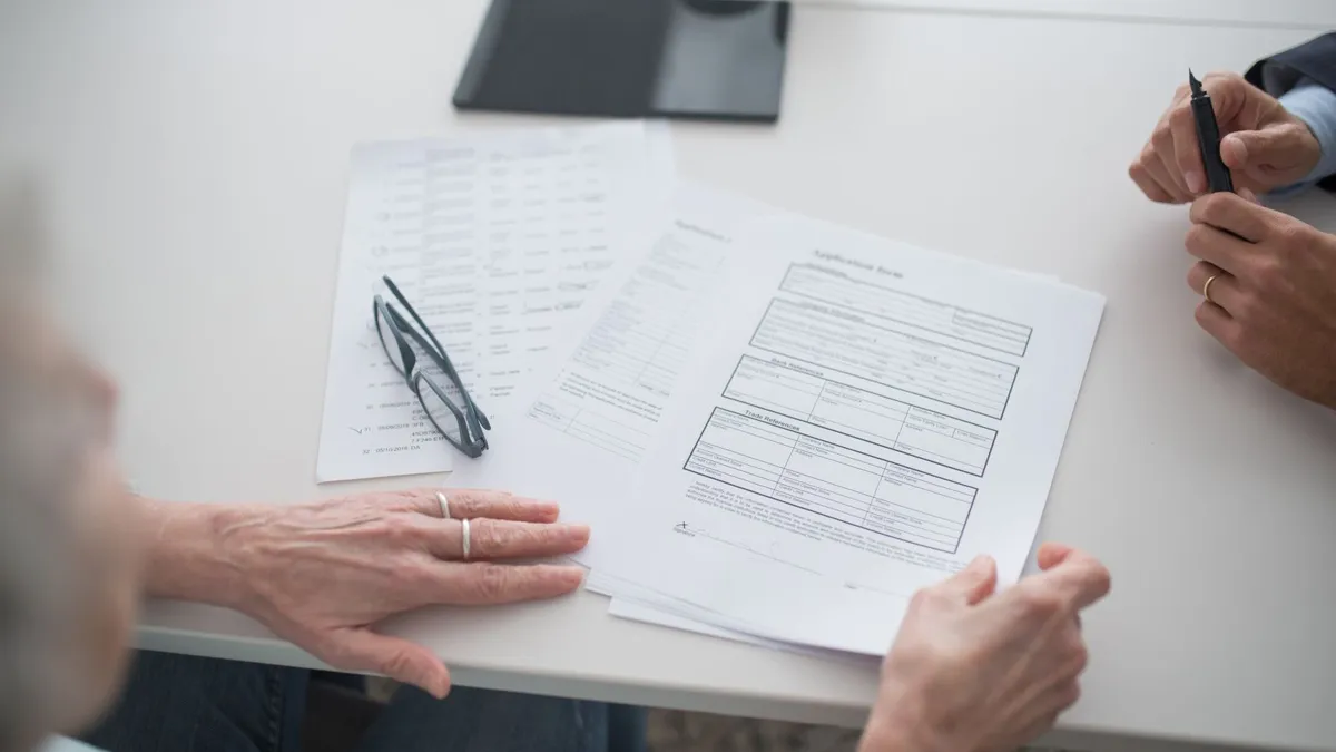Two people comparing printed documents before arranging a birth certificate translation